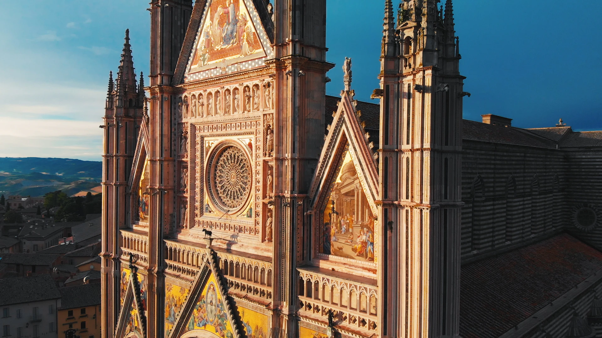 Facade of a gothic cathedral with ornate decorations, stained glass windows, and detailed mosaics depicting religious scenes.