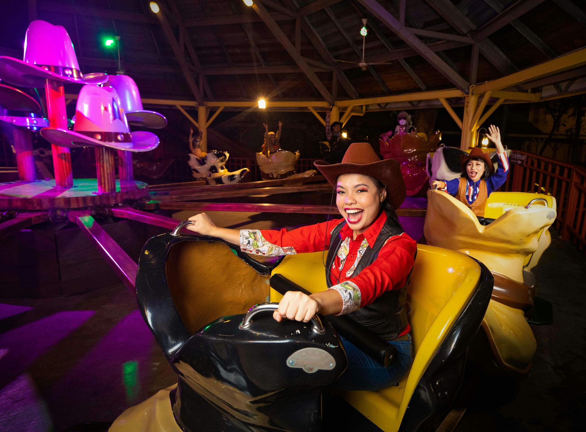 晚上，人们打扮成牛仔，在木制亭子里享受旋转的娱乐活动，灯光明亮。