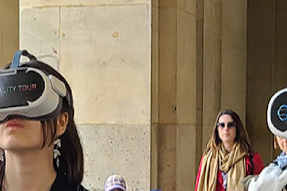 A group of people wearing virtual reality headsets stand in a historical building corridor.