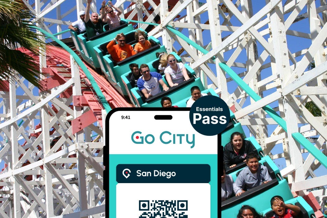 전경에 "Go City San Diego Essentials Pass" 가 표시된 휴대폰 화면이 있는 롤러코스터를 탄 사람들.