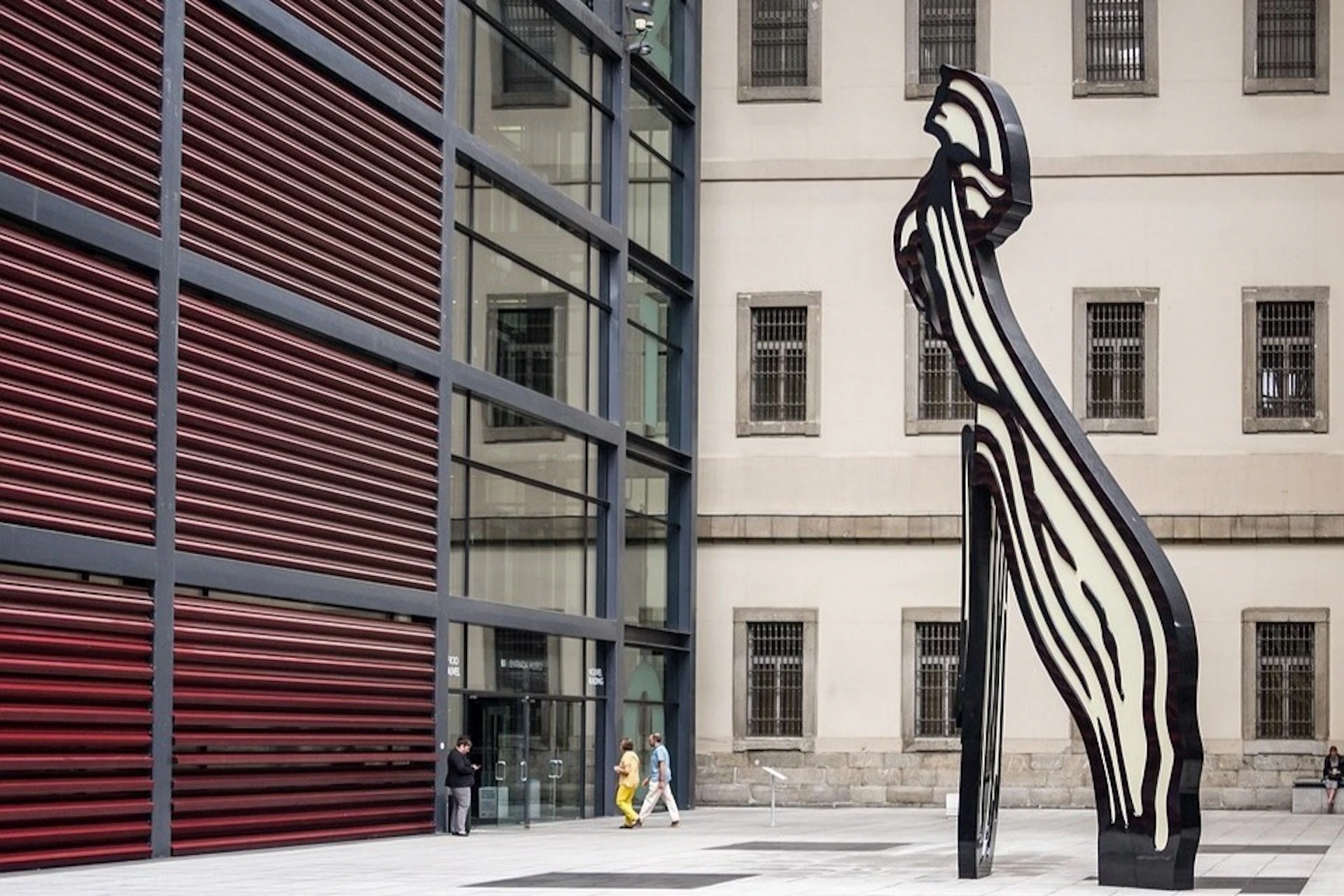 Main entrance of the Reina Sofía Museum in Madrid, with visitors entering the building.