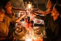 Šťastné páry si připíjejí sklenkou vína na romantickou večeři
