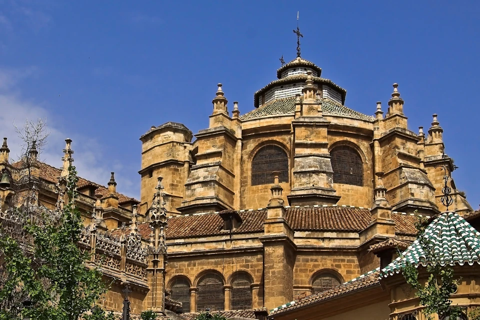 A historic building with ornate stone architecture and a domed roof under a clear blue sky.