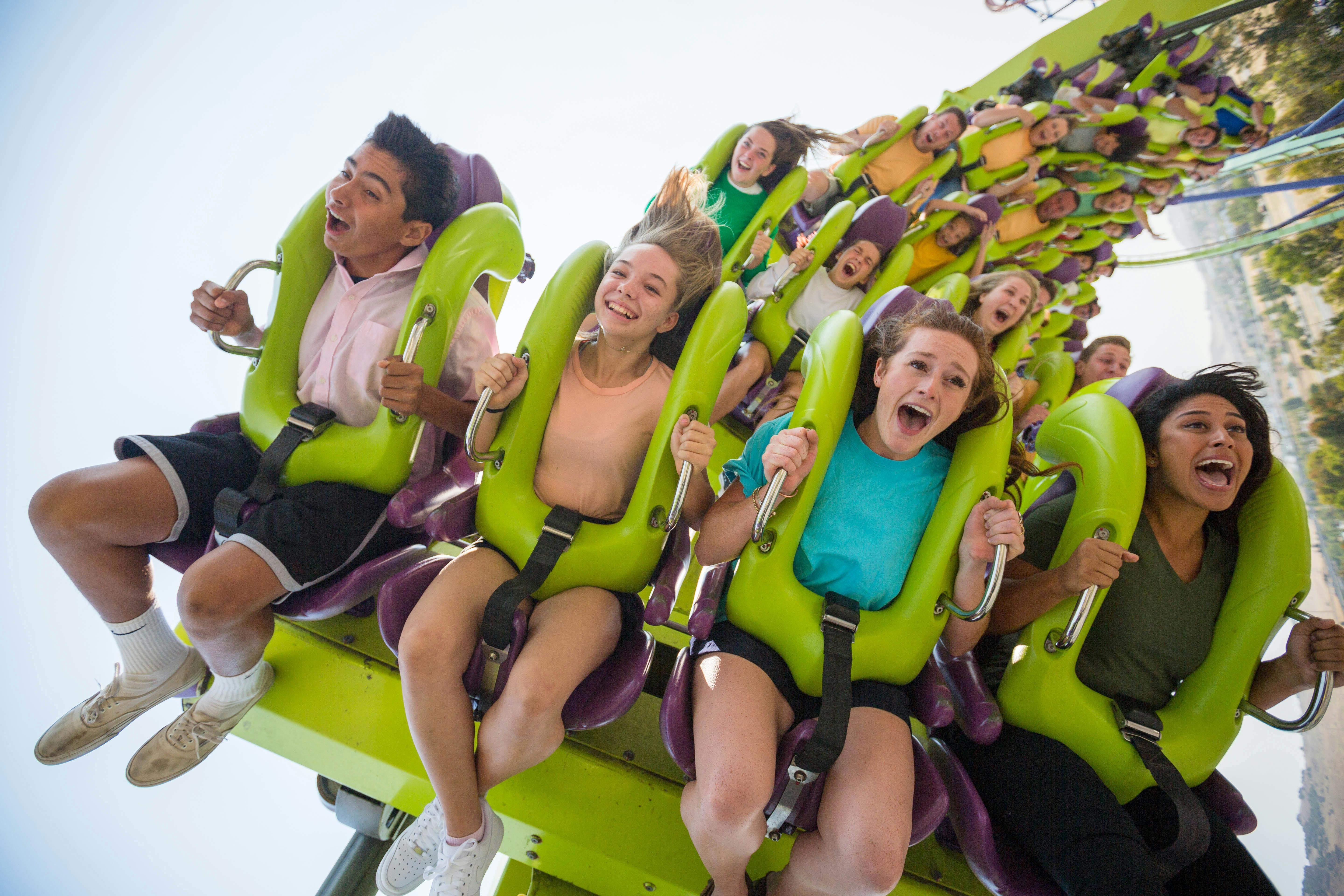 五个穿着泳装的男孩在水上乐园向镜头跑去，背景中有水飞溅。