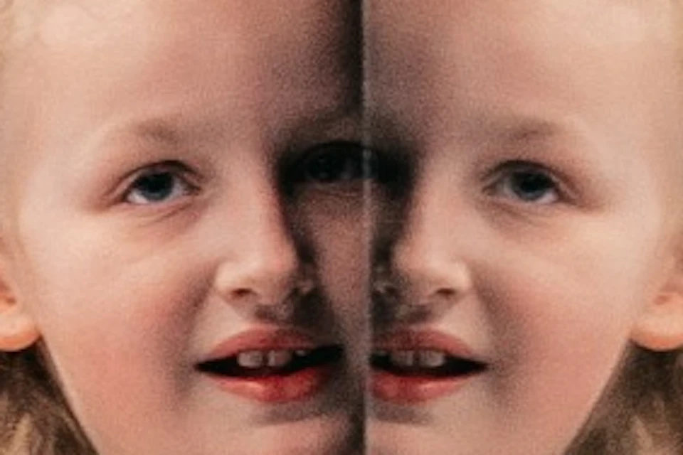 A woman and a child are standing in front of a blue and white striped wall with a mirror, creating an optical illusion.