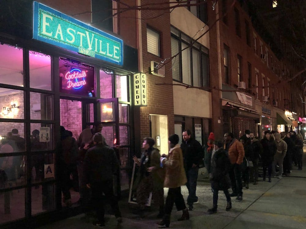 晚上，一队人在喜剧俱乐部外面的城市街道上等候；一个霓虹灯牌上写着“韦斯特维尔”。