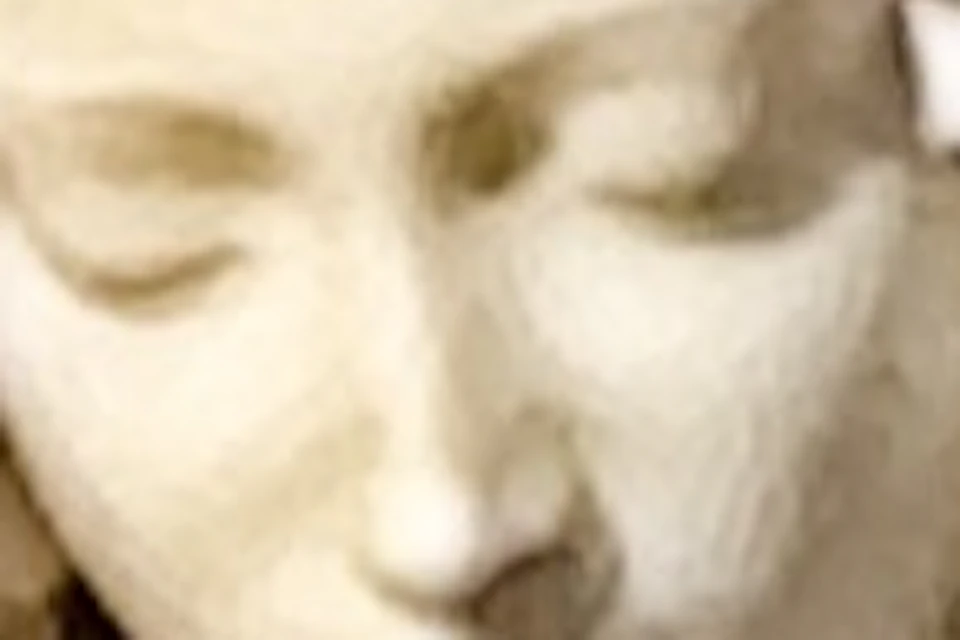 A marble sculpture depicting a seated figure holding a reclining figure, set against a detailed stone background.