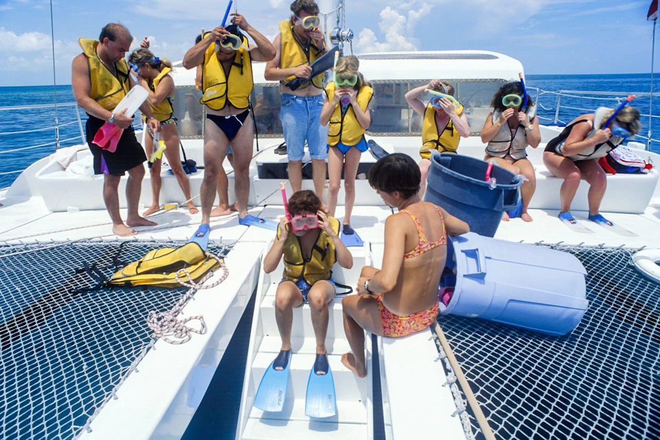 Expert staff help you fit your snorkeling equipment on the boat