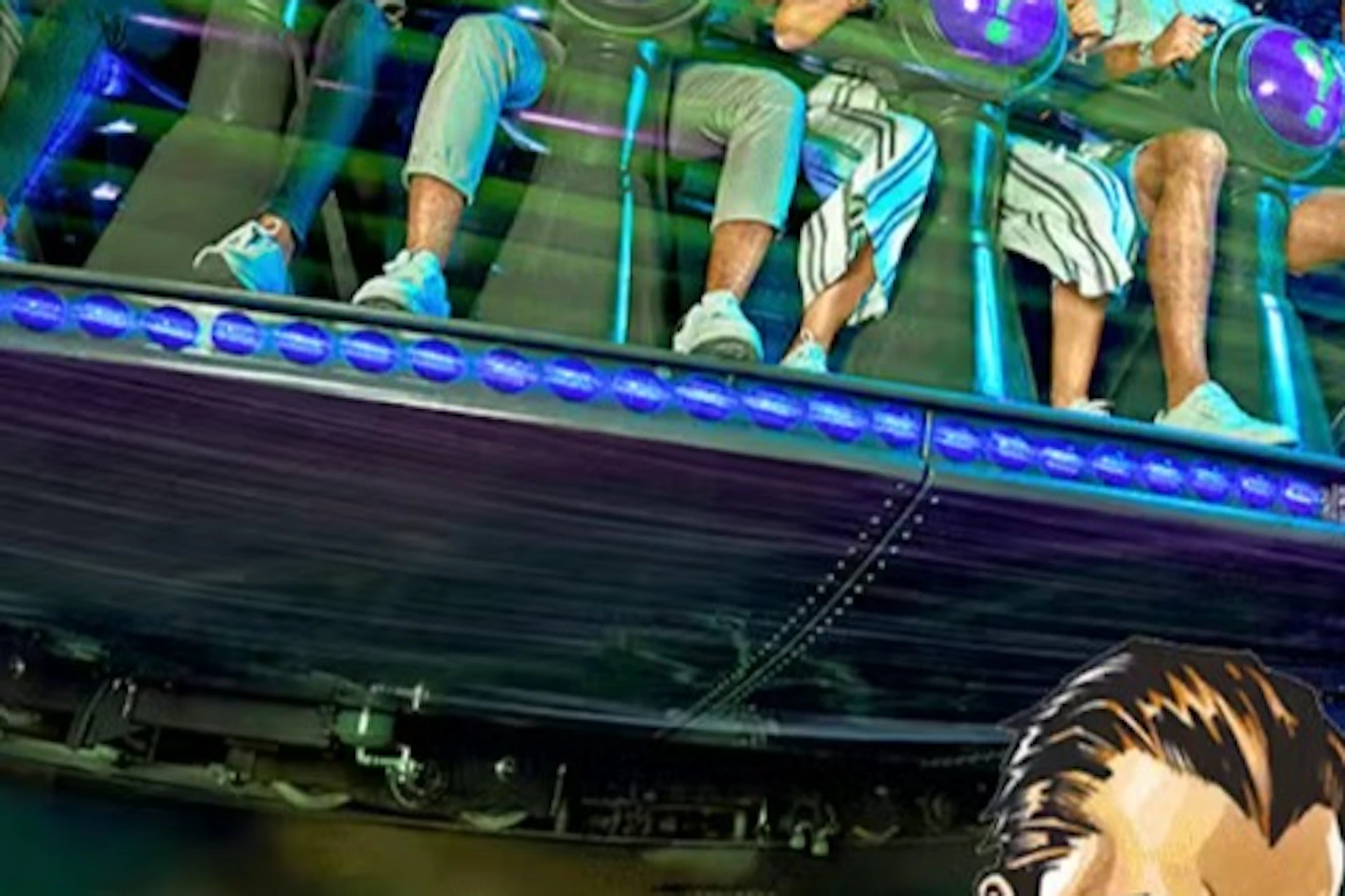 A group of people seated on a spinning amusement ride with a colorful Riddler-themed design and lit with bright lights.