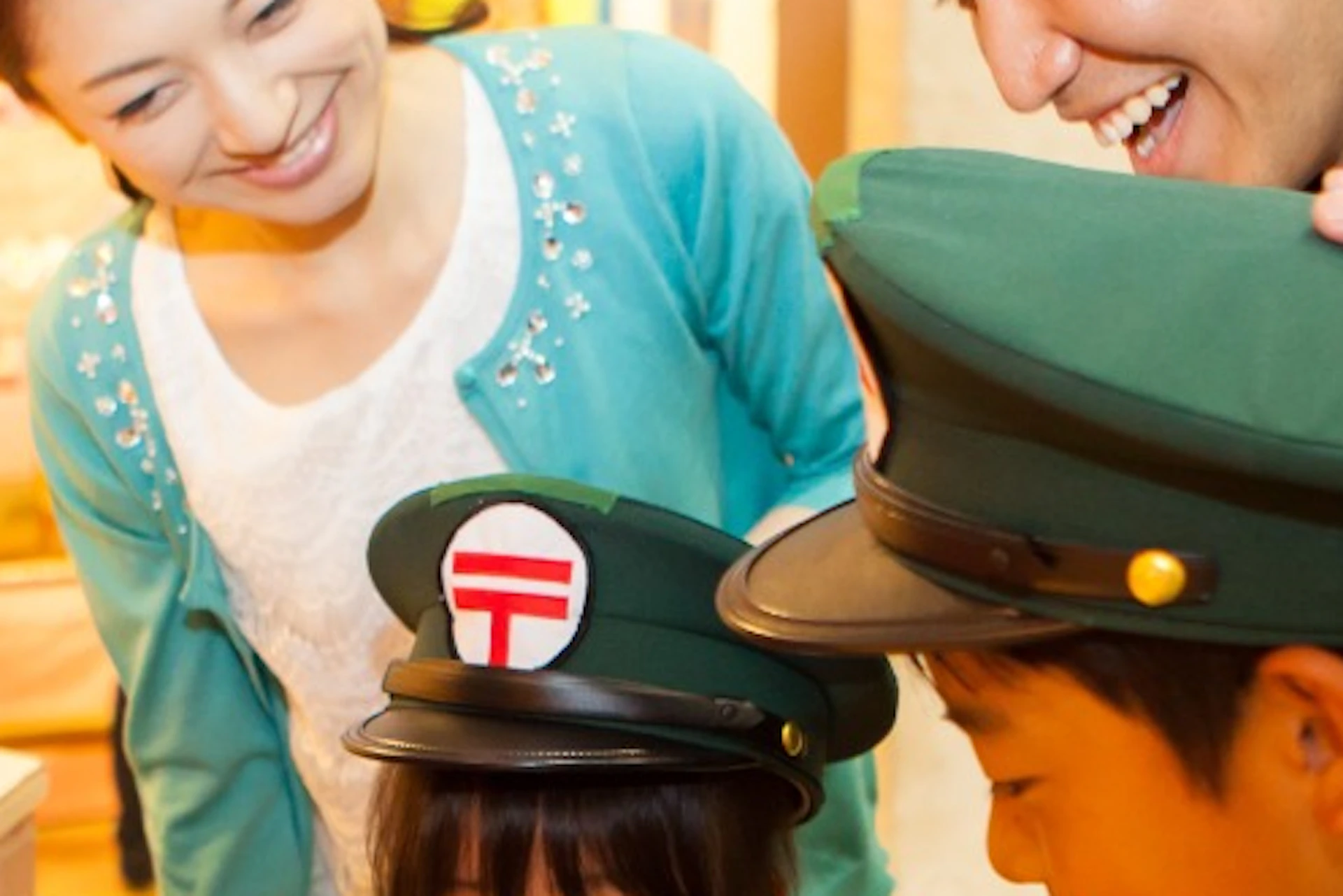 Children dressed as postal workers interacting with a red mailbox, accompanied by two smiling adults in a playful setting.