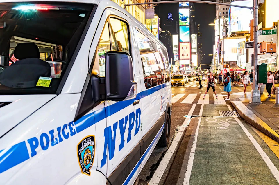 Times Square at night with NYPD police car