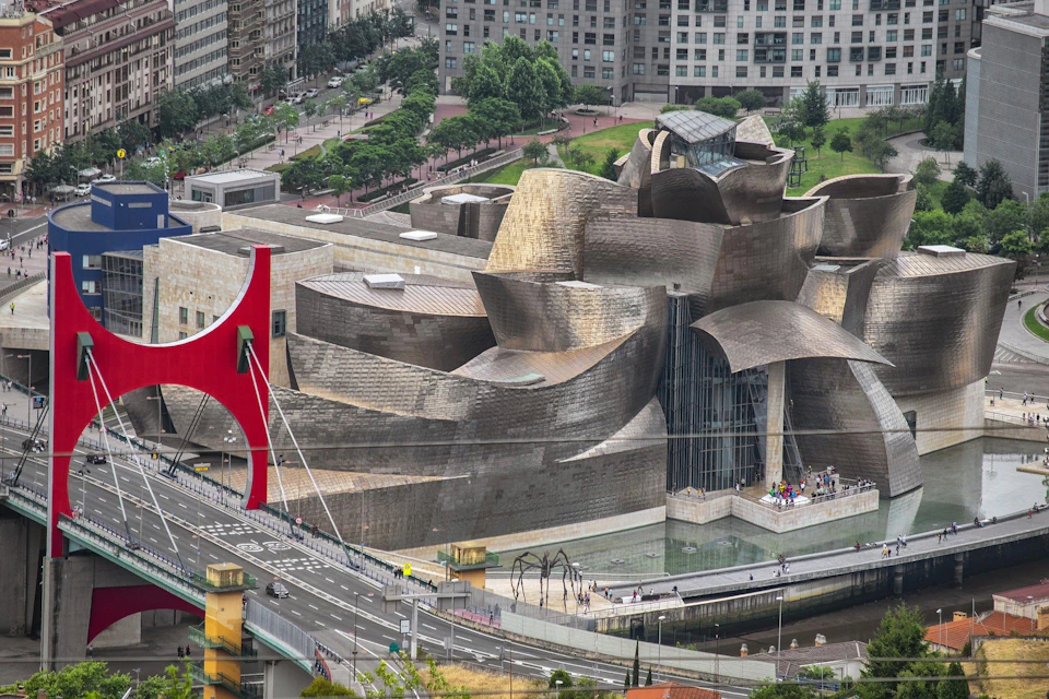 Aerial view of the Guggenheim Museum Bilbao, featuring its distinctive curved architecture and surrounding urban landscape.