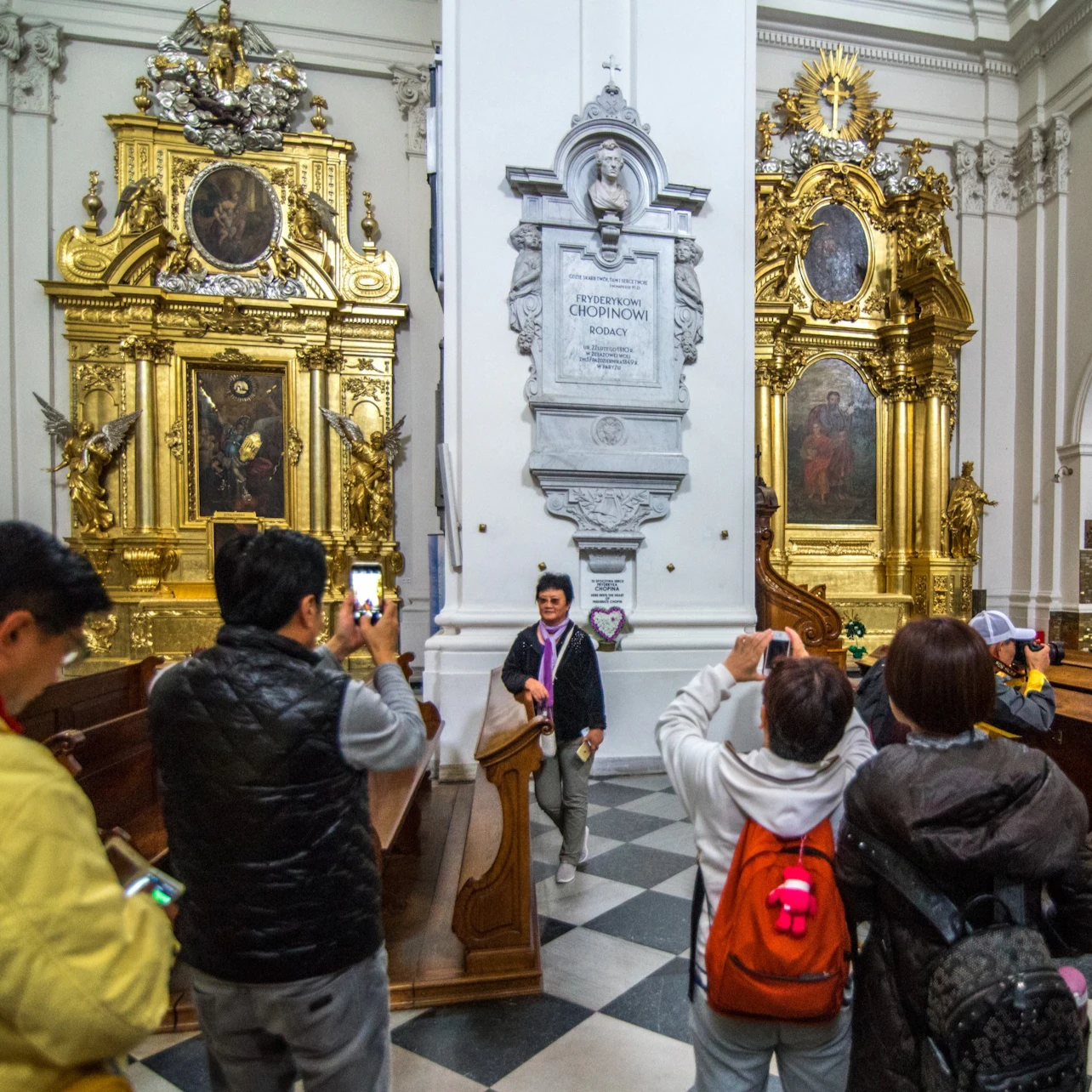 People viewing the plaque commemorating Chopin in the Holy Cross Church in Warsaw
