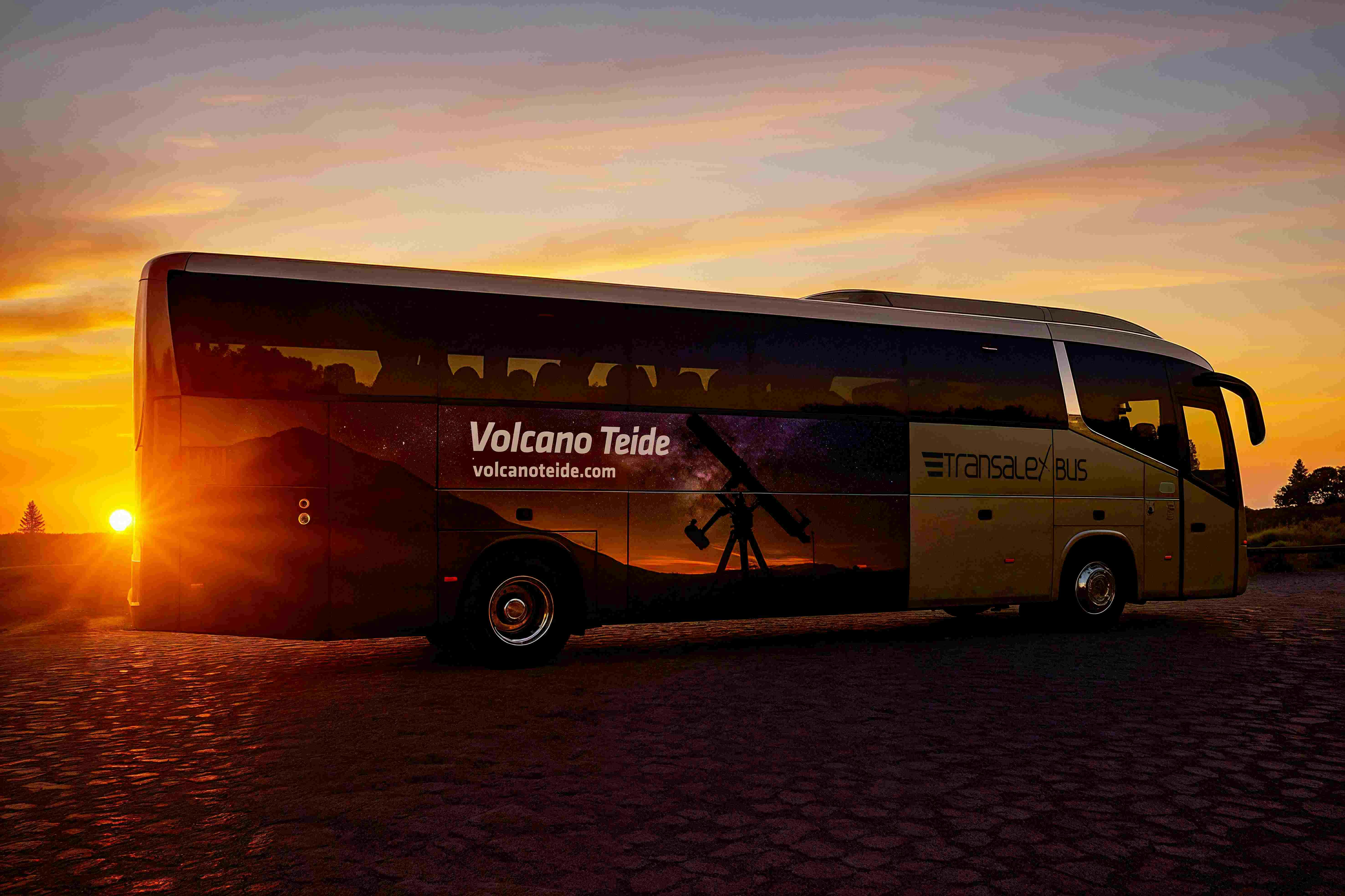 「ボルケーノ・テイデ」と「トランザレックス・バス」のブランディングが施されたバスは、夕暮れ時に駐車し、風景と望遠鏡のグラフィックを紹介しています。