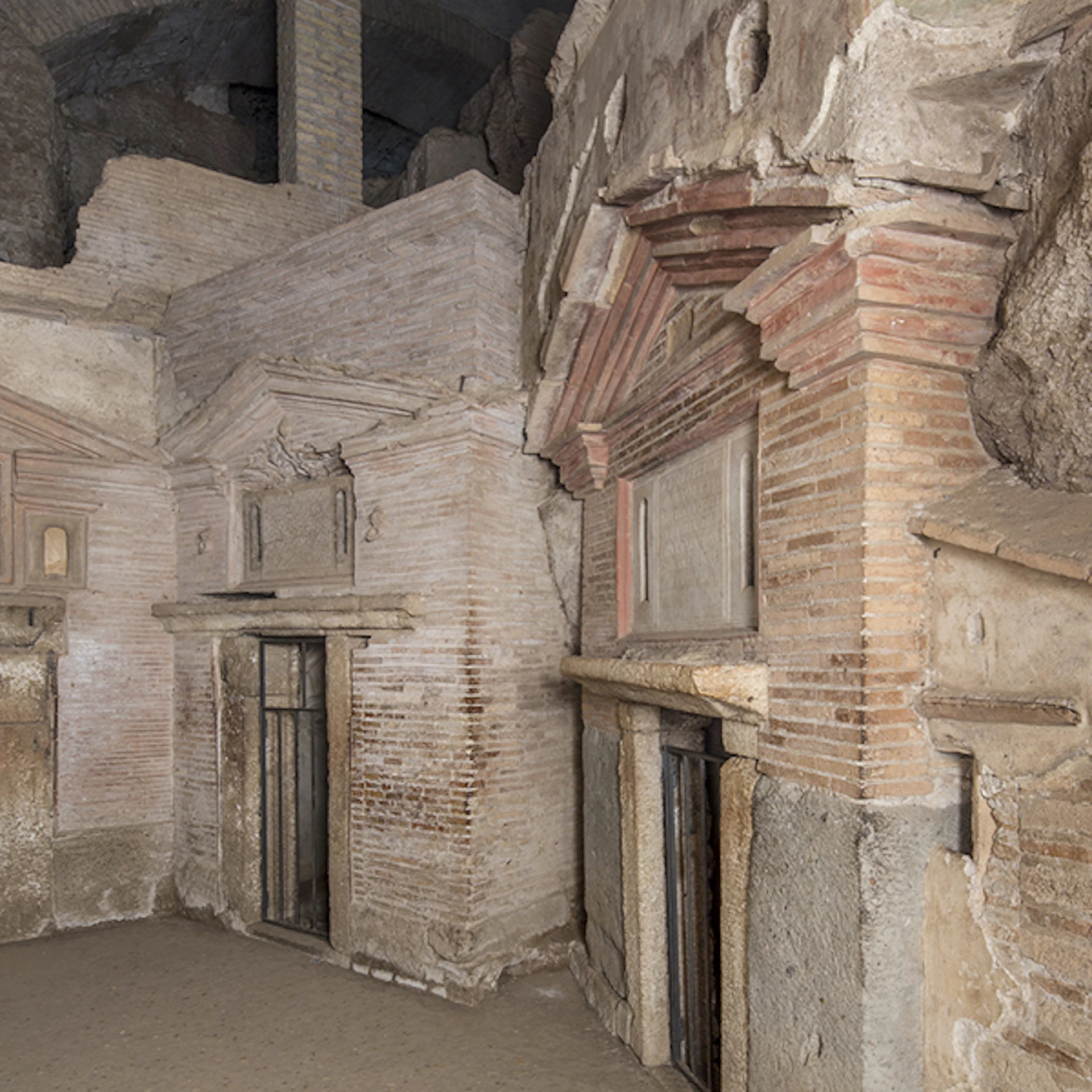 Ancient stone and brick structures with detailed arches and doorways in a historical site. No people present.