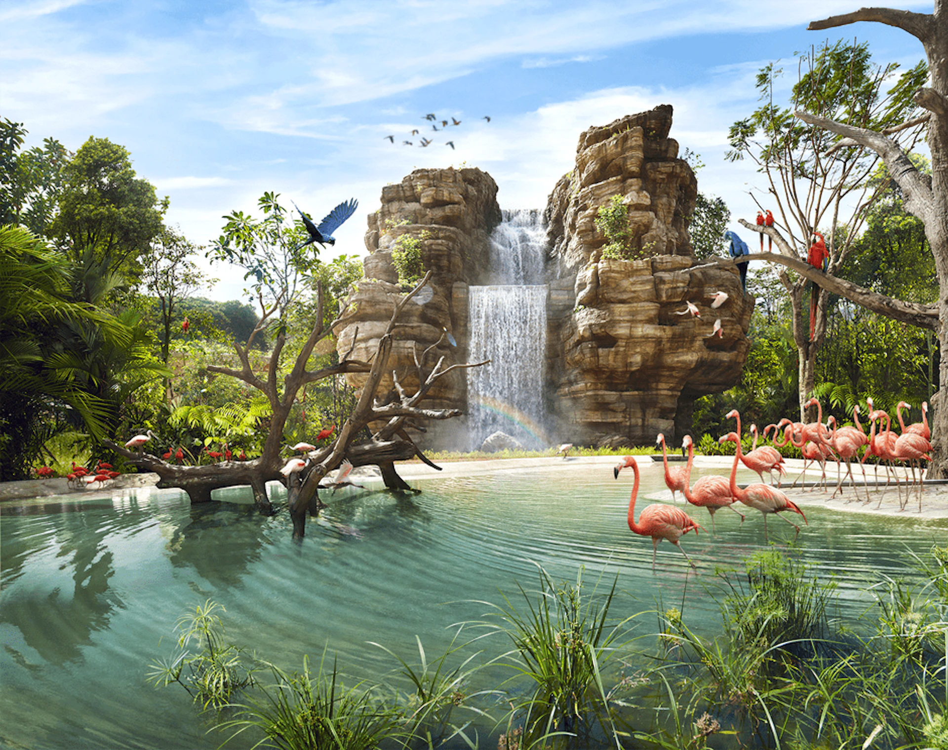 Waterfall flows over rocks into pond with flamingos, trees, and colorful birds in a lush, green landscape under a blue sky.
