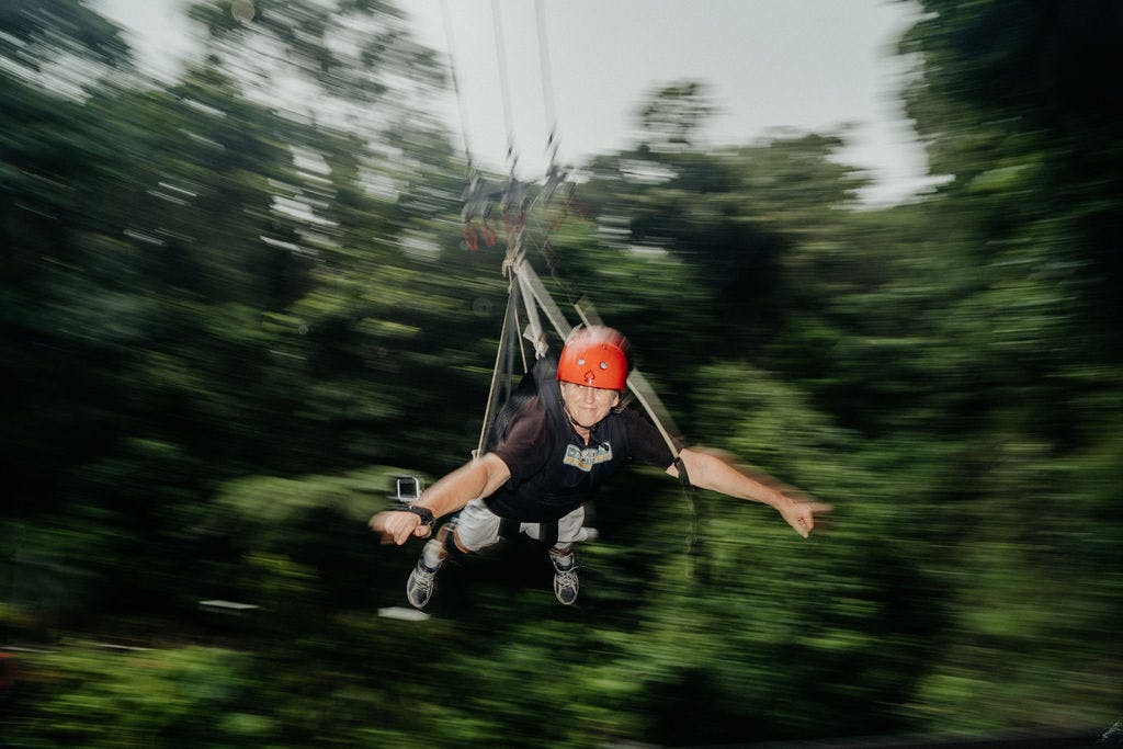 穿过郁郁葱葱的绿色森林，身穿红色头盔和黑色衬衫的人。