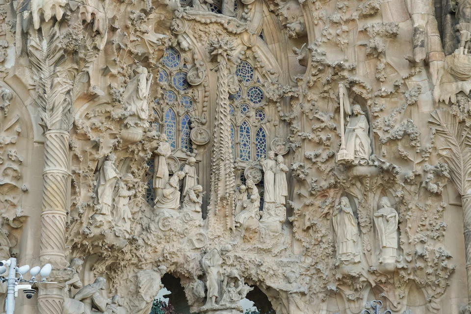 Intricate stone carvings depicting religious scenes and statues on the facade of a Gothic-style cathedral.