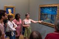 Guide explaining the painting Starry Night over the Rhone by Van Gogh
