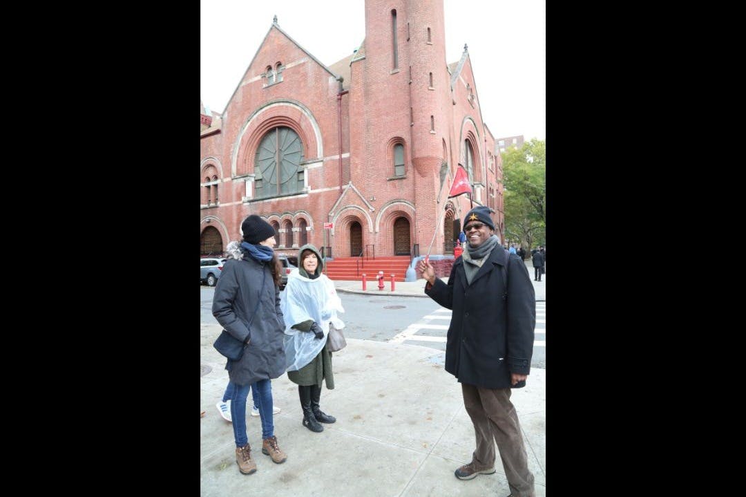 Μια ζωντανή φωτογραφία του ξεναγού μας που στέκεται περήφανα μπροστά από την εμβληματική εκκλησία του Χάρλεμ.