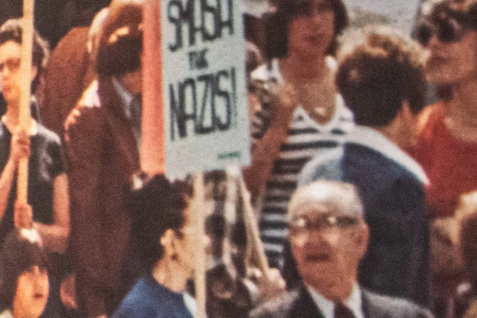 A museum exhibit displays historical protest photos and signs with messages about freedom of speech and opposition to Nazis.
