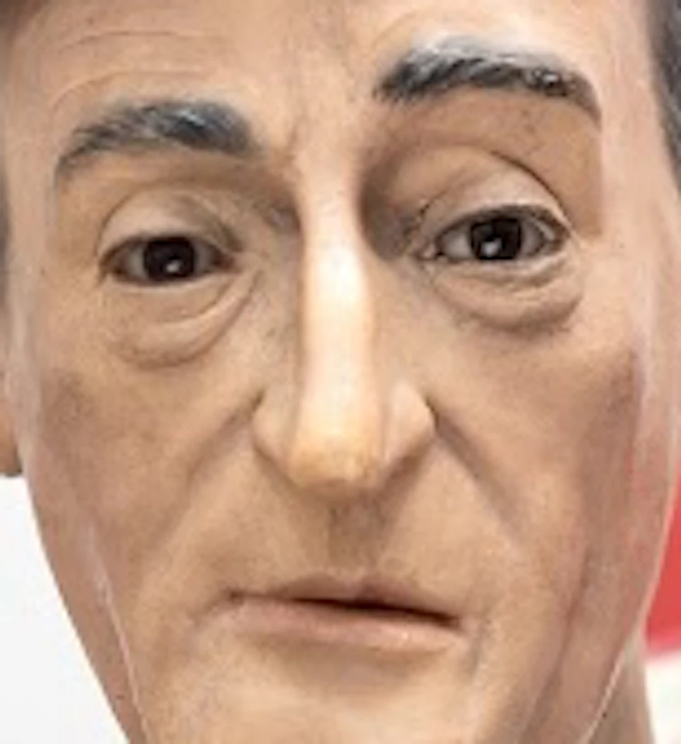 A wax figure wearing a black bowler hat, white shirt, black bow tie, and a suit, with a neutral facial expression.