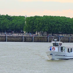Bateau l'Aquitania naviguant face à la place des Quinconces et le long des facacades bordelaises.