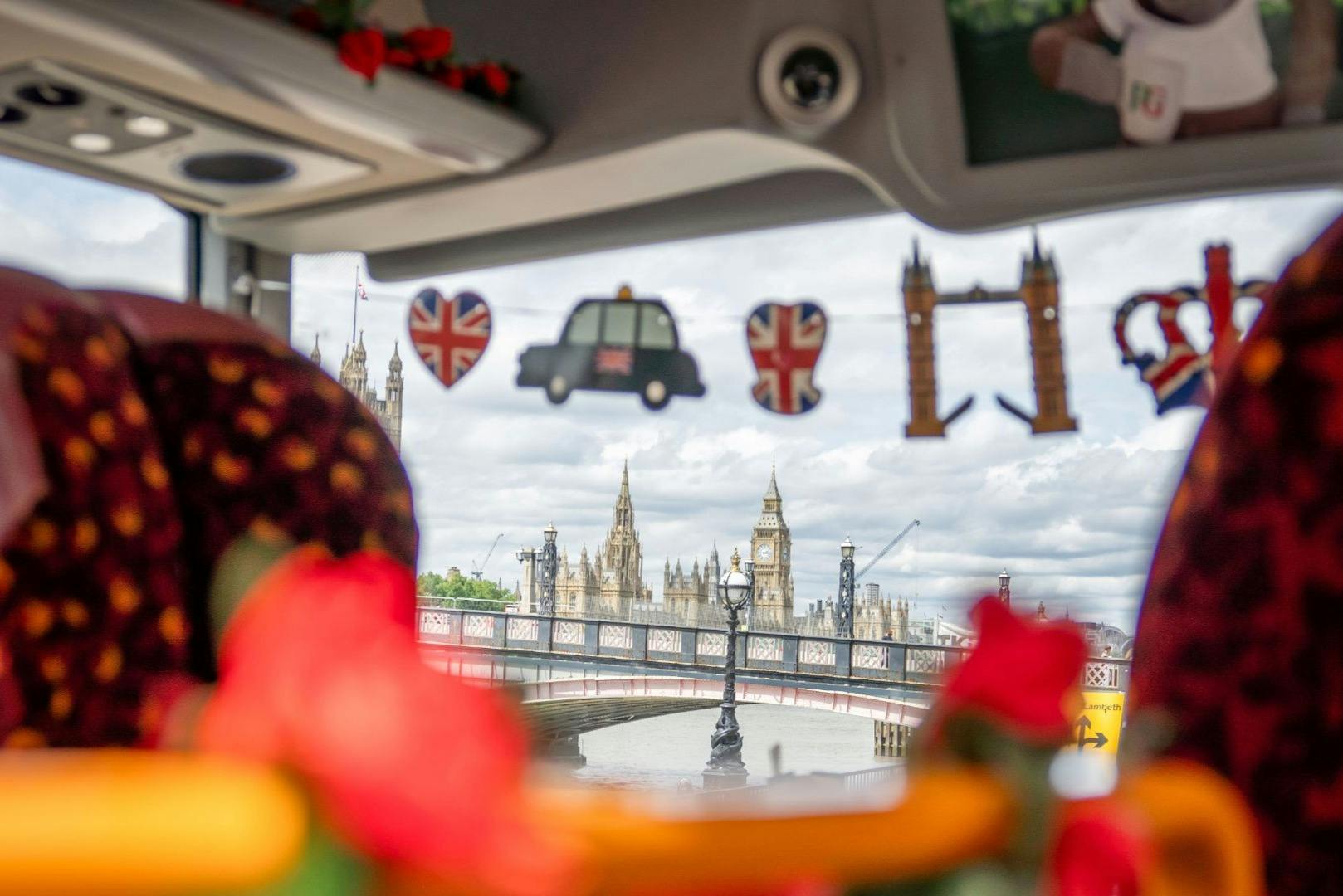 View of Big Ben and Westminster Bridge through a decorated vehicle window with British-themed ornaments.