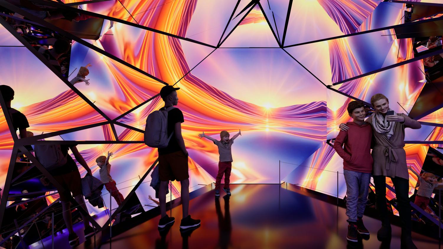 People standing in a room with reflective surfaces and vibrant, colorful light patterns resembling a sunset.