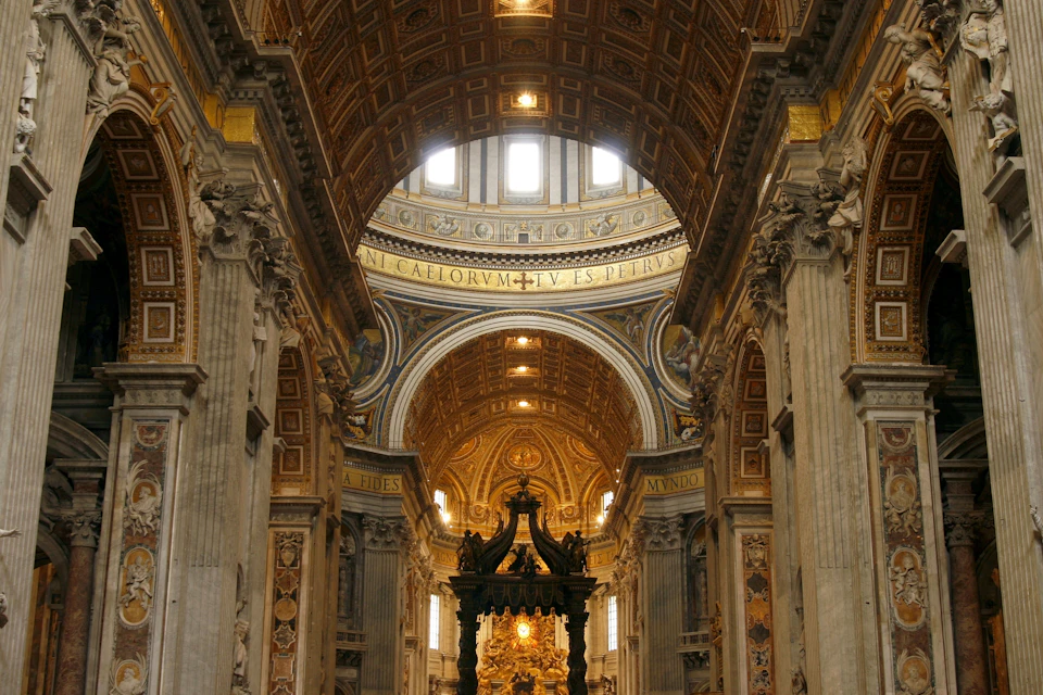Ornate interior of a grand cathedral with golden domes, columns, and religious inscriptions. A black altar stands in the center.