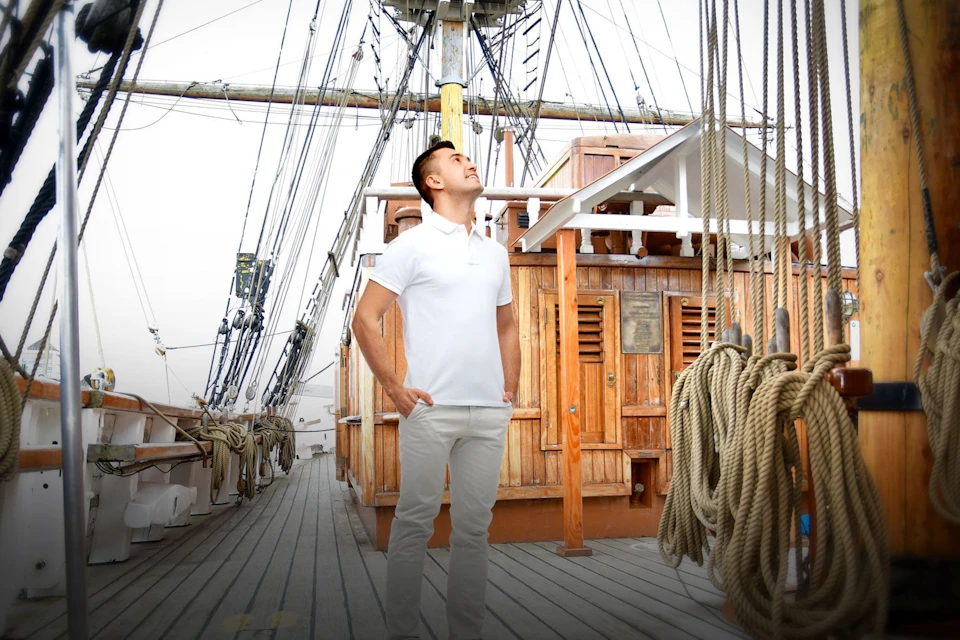 Man standing on a ship looking up at the sky