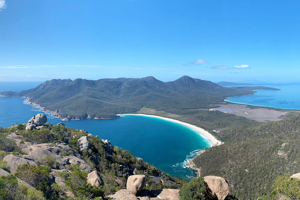 Expansive views of the Freycinet peninsula, with Wineglass Bay beach and the Hazards beach in the background