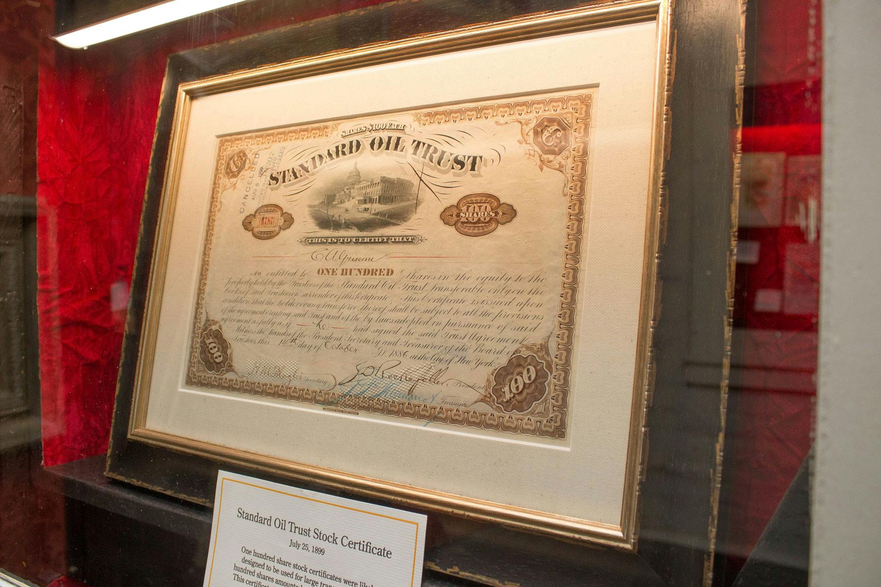 Ett inramat Standard Oil Trust-aktiecertifikat som visas på en vägg med en beskrivande plakett under.