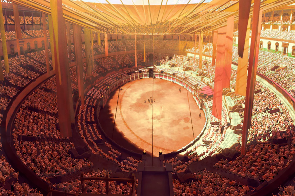 A large circular indoor arena filled with a crowd and a performance taking place in the center under warm lighting.