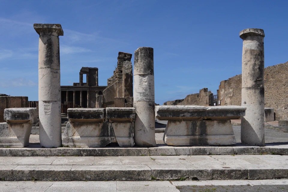 Ancient ruins with stone columns and structures under a clear blue sky.
