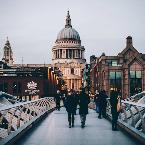Människor som går på Millennium Bridge i London, med St Paul's Cathedral i bakgrunden och City of London School synlig.