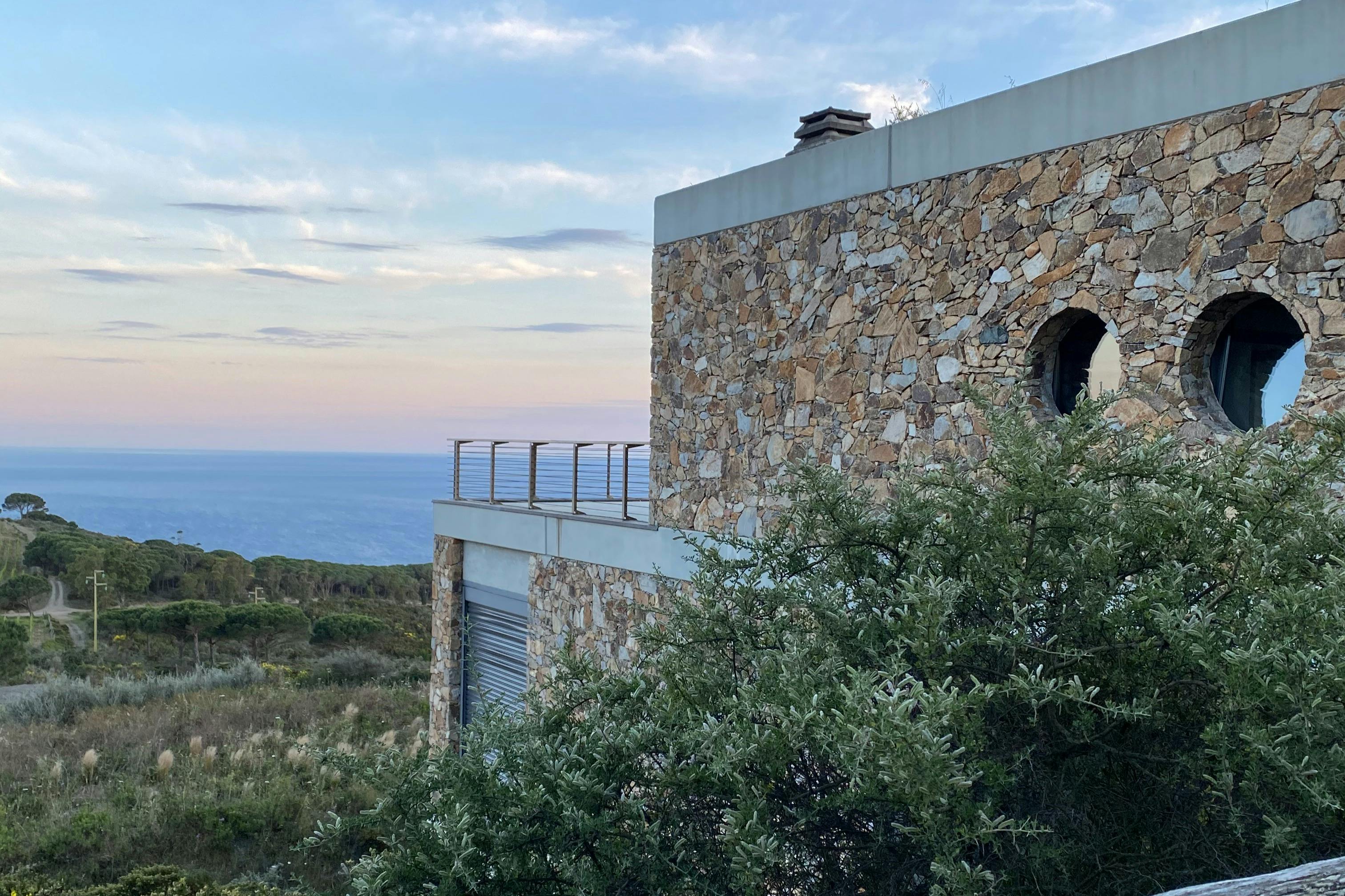 Vue latérale de la cantine, avec oblò et terrazza avec vue sur la mer et les vigneti. A proximité se trouve la macchia méditerranéenne.