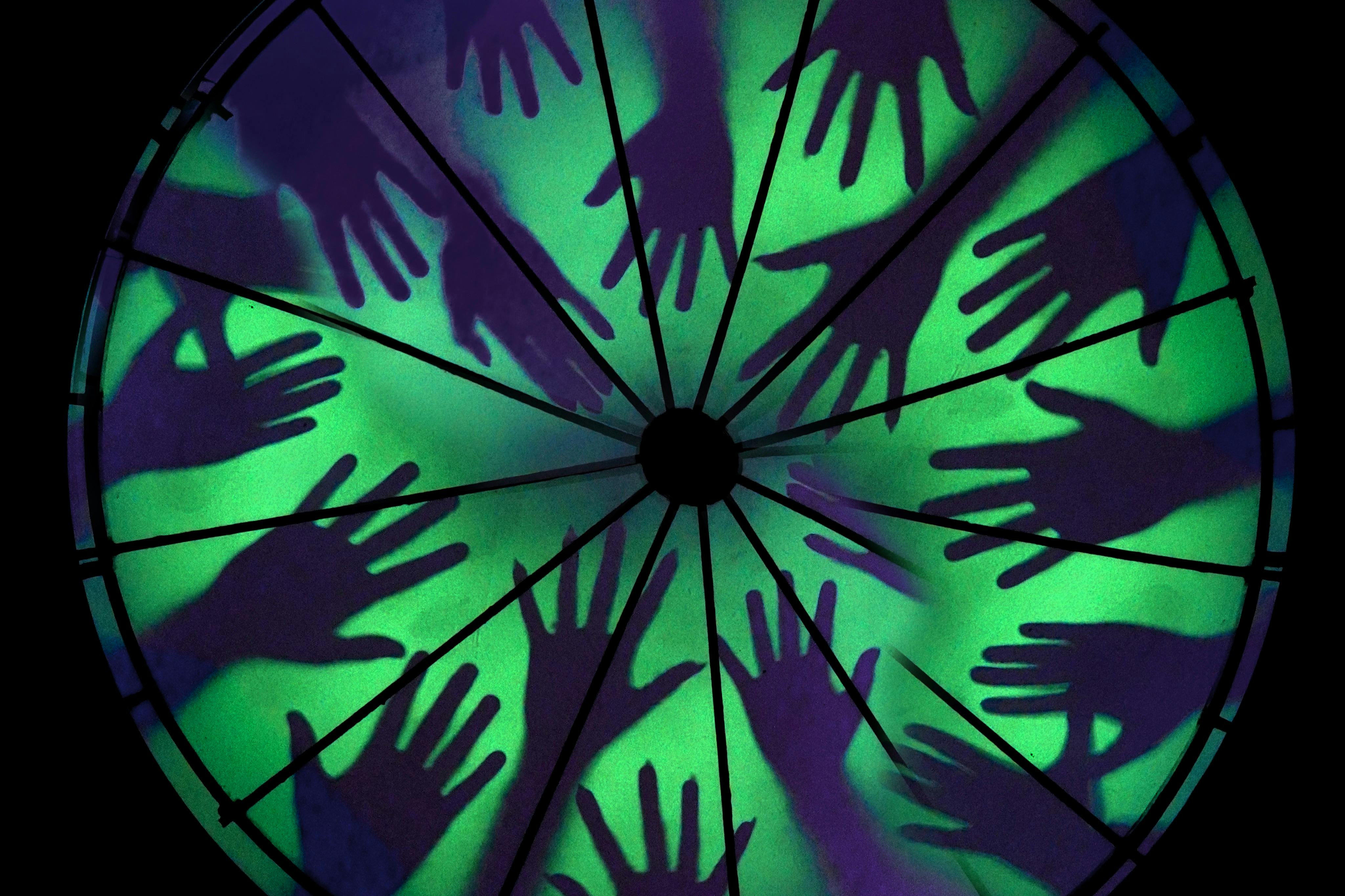 各种姿势的手形轮廓，在绿色和紫色背景上形成径向图案。