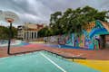 Parque infantil con canasta de baloncesto y obras de arte callejero en las paredes y el suelo.