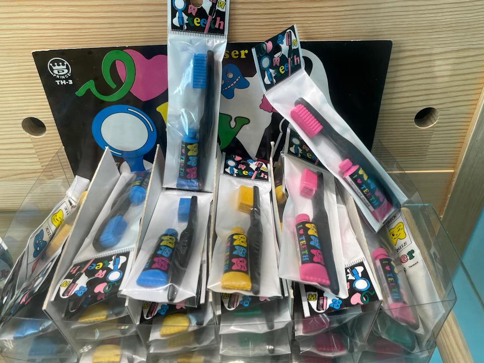A display of colorful novelty toothbrushes in packaging, arranged on a shelf with a decorative background.