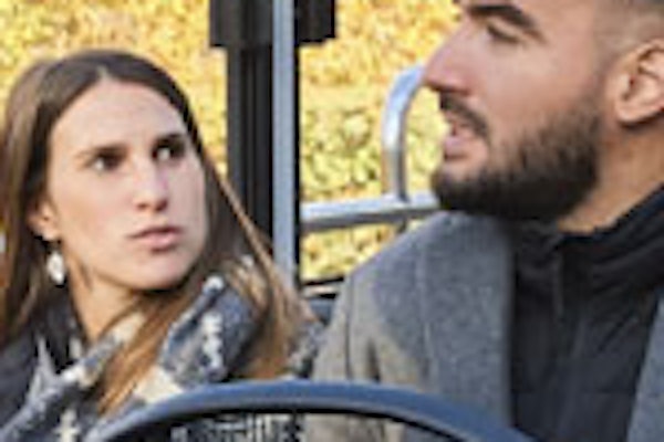 Personas sentadas en el interior de un autobús turístico con techo de cristal, contemplando edificios históricos y árboles en un día soleado.