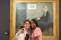 Dois convidados tirando uma selfie em frente à pintura da mãe de Whistler