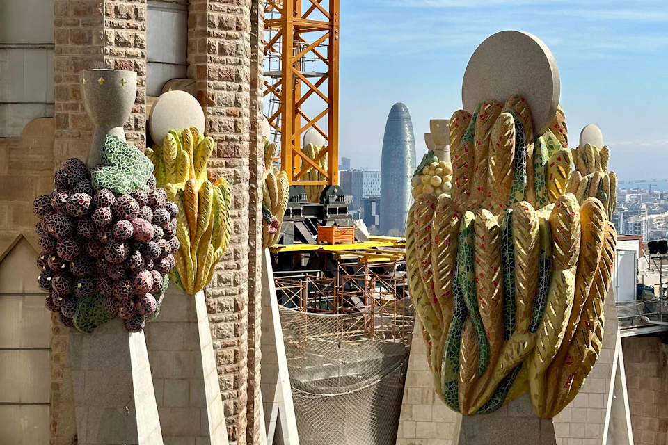 Architectural details with colorful mosaic fruits and grains, a construction crane, and a cityscape featuring a modern tower.