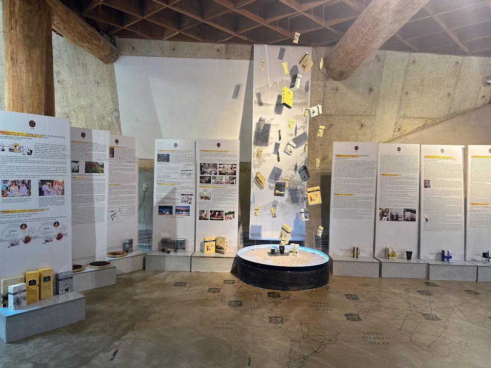 An exhibition with panels displaying text and images, a central circular display, and suspended items above it.