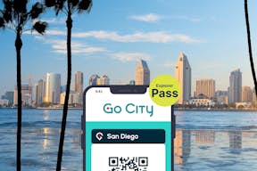 San Diego Explorer Pass da Go City exibido em um smartphone com o horizonte da cidade e o porto ao fundo