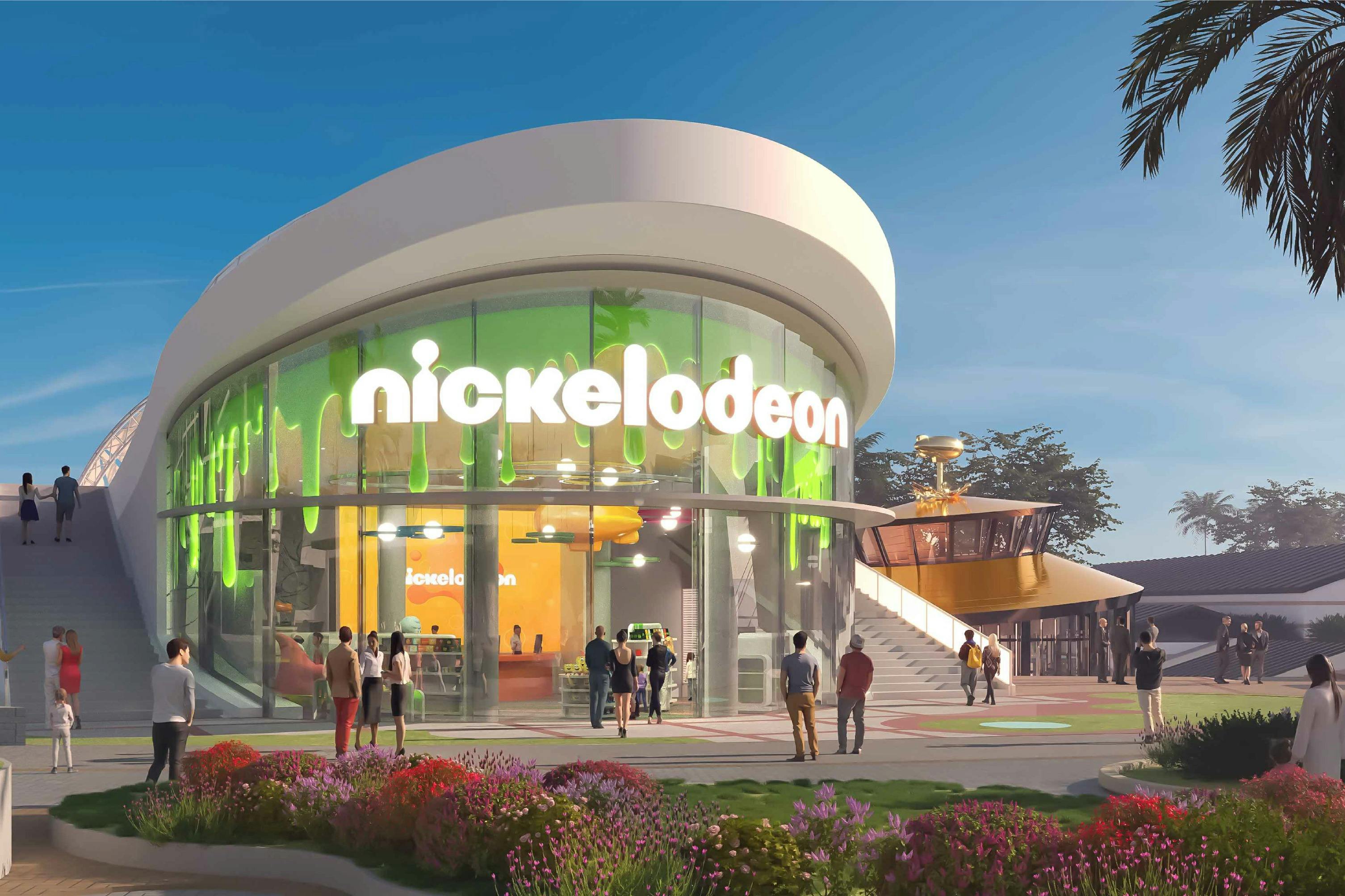 En modern Nickelodeon-byggnad med en böjd design, gröna accenter och människor som går utanför, mot en klar himmel.