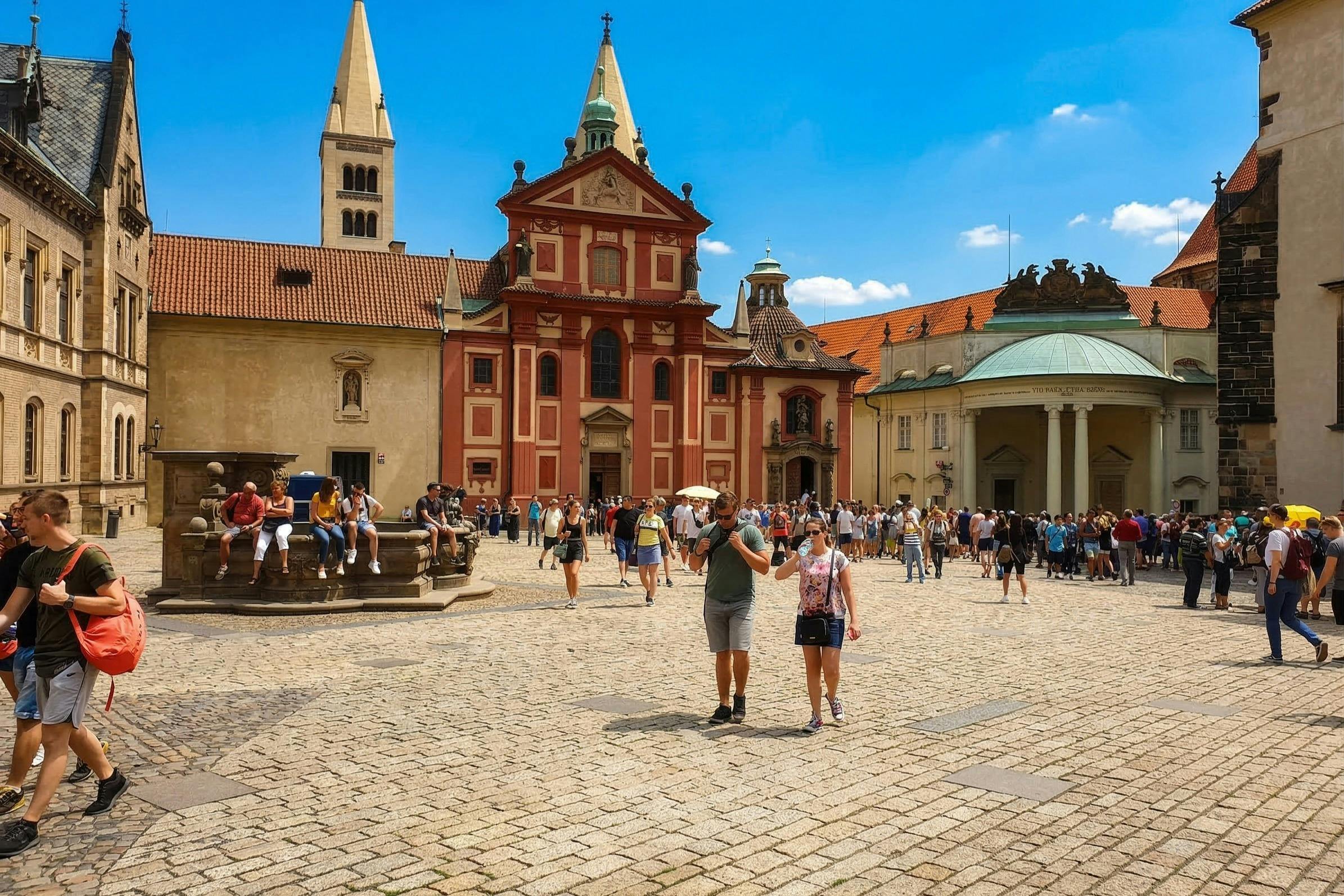 Ett livligt torg med historiska byggnader, inklusive en röd kyrka, och många människor som går eller samlas i grupper en solig dag.