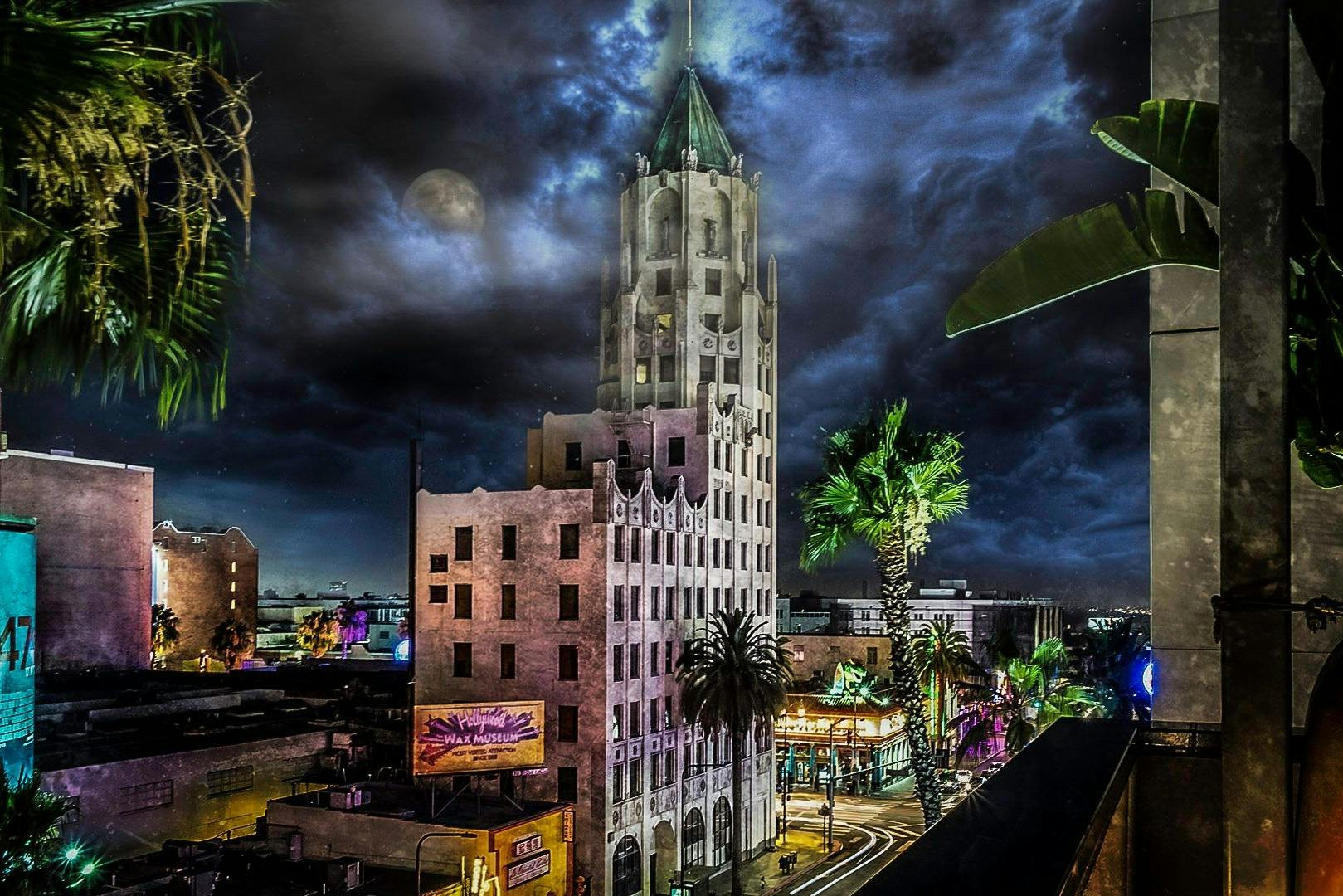 Spooky nighttime photo of the LA skyline and the famous Hollywood Wax Museum, under the clouds and moonlight