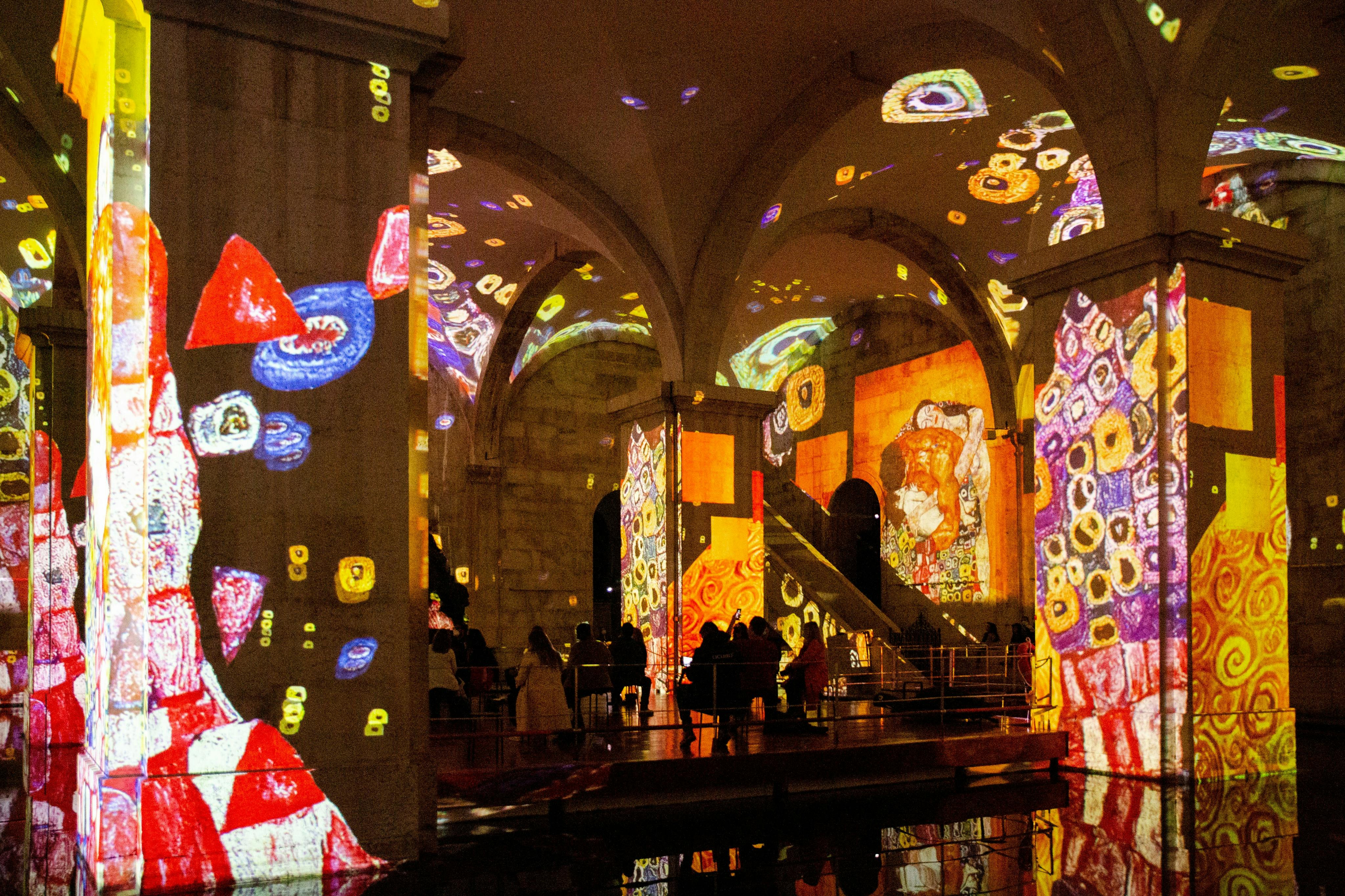 アーチ型のホールの中には、顔や幾何学模様など、壁や柱にカラフルな抽象芸術が映し出されています。