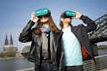 Gäste mit VR-Brillen vor der Kölner Sykline